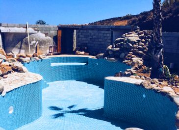 Swimming pool with built-in rock feature, created by Almeria Pools